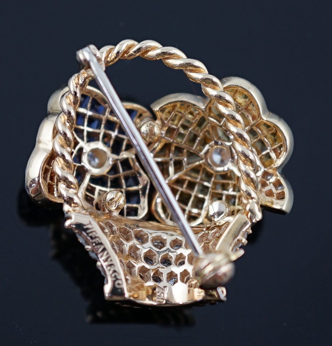 A Tiffany & Co 18k gold, two colour sapphire and diamond cluster set brooch, modelled as a basket with two flower heads
